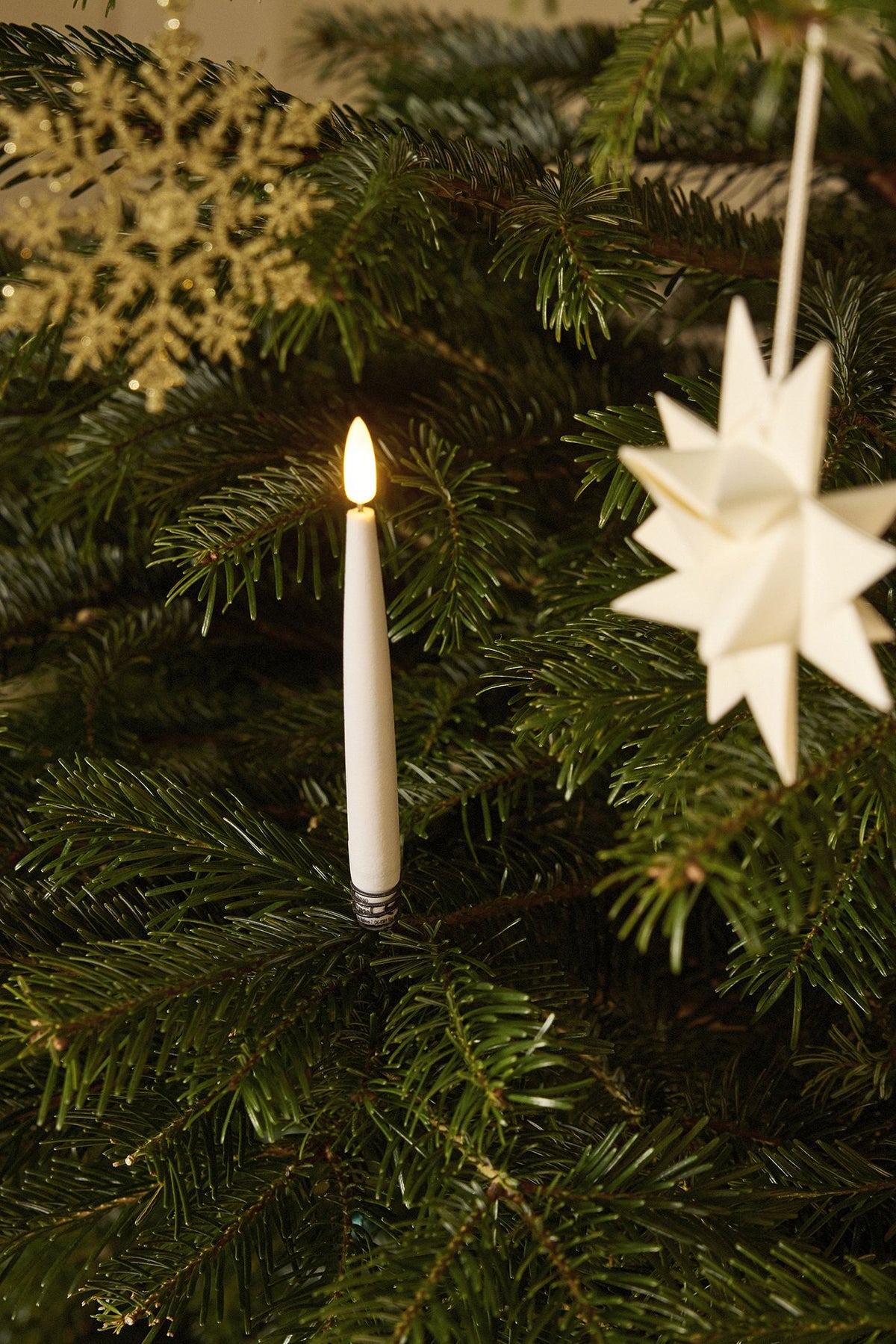 Nærbillede af LED-stearinlys og stjerne på juletræet