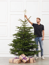 Mand står ved siden af juletræ som måler 2.00-2.25 meter