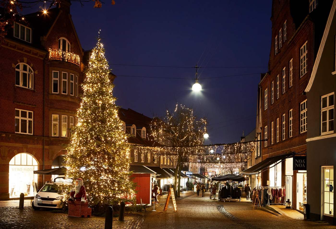 Stort juletræ med lyskæde som juleudsmykning på gågaden